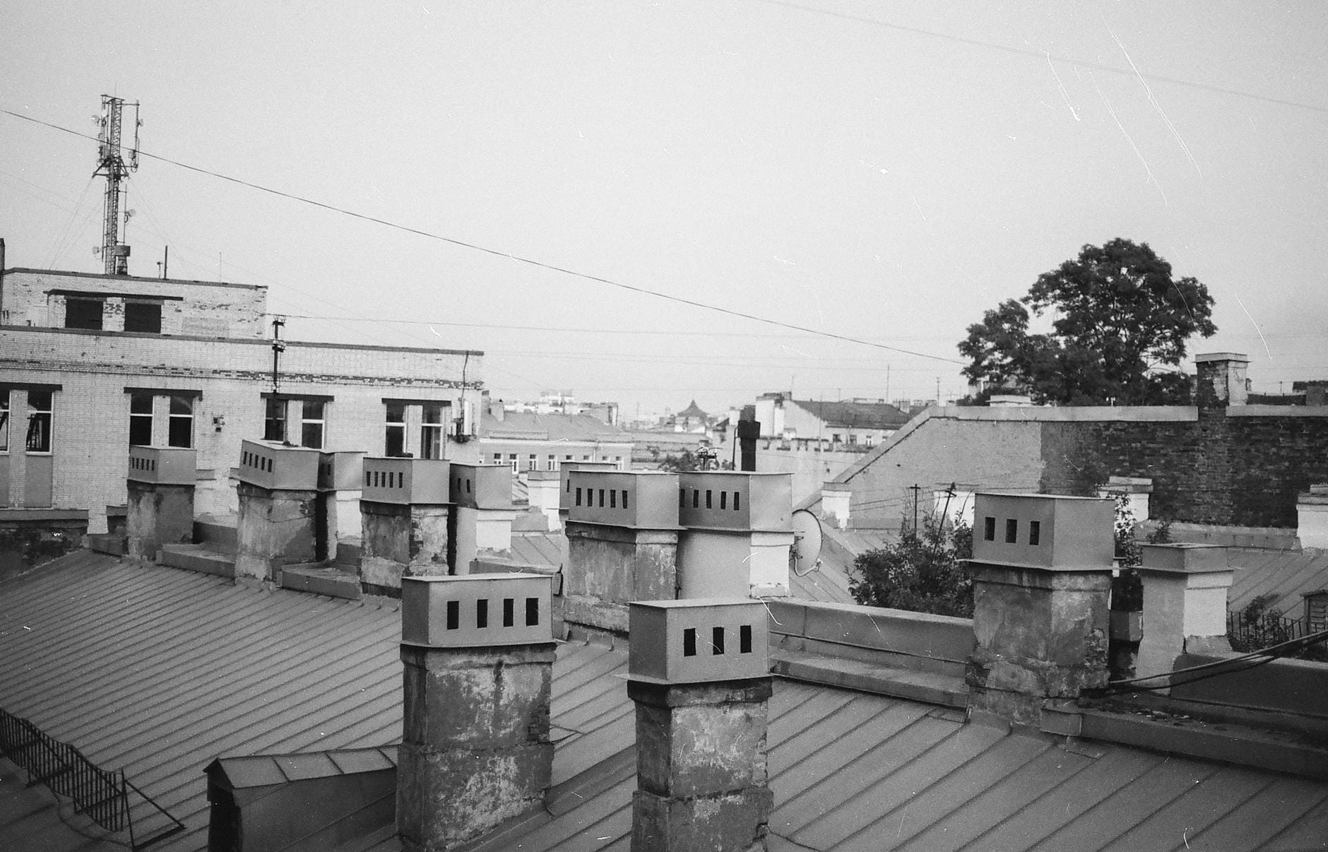 Black and white photo of chimneys atop urban rooftops in St. Petersburg.